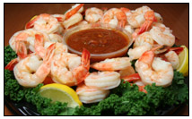 An array of cooked shrimp around a bowl of cocktail sauce; fresh and frozen shrimp can be bought by the pound in Western MA at The Other Brother Darryl’s, which sells fish, seafood, and shellfish galore. 